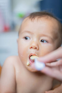 Cropped hand feeding baby boy