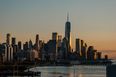 Modern buildings in city against sky during sunset