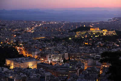 High angle view of illuminated cityscape against sky at night