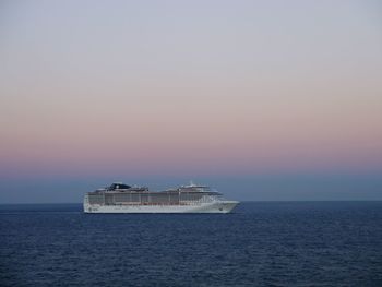 Ship sailing on sea against sky during sunset