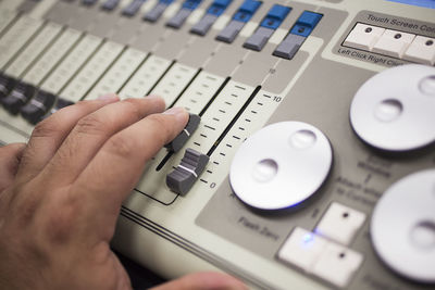 Cropped hand operating sound mixer