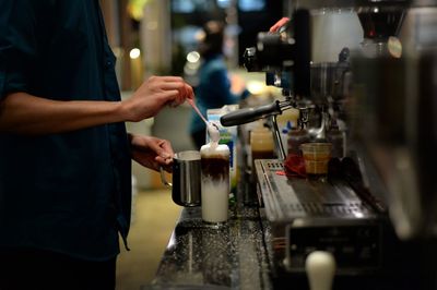 Midsection of man preparing food in cafe