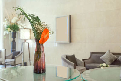 Anthurium in a glass vase placed on a glass table