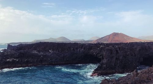 Scenic view of sea and rocks against sky