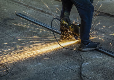 Man cuts metal with angle grinder