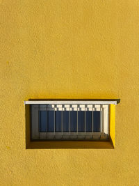 Close-up of yellow window on wall