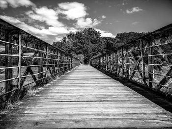 Empty footbridge leading towards trees