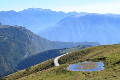 Scenic view of lake by mountains against sky