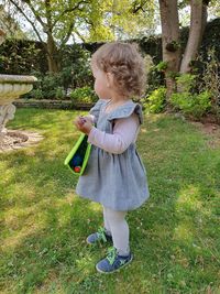 Side view of girl standing on grassy land