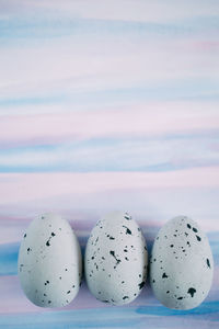 Close-up of quail eggs against colored background