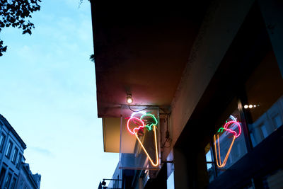 Low angle view of illuminated advertisement in city