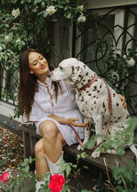 Portrait of woman with dog on bench