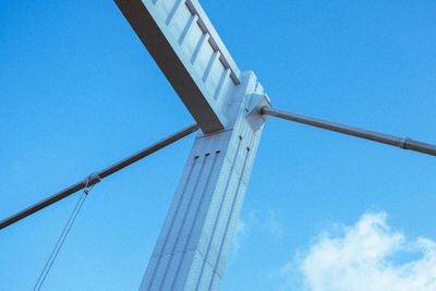 Low angle view of crane against clear blue sky