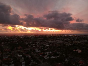 Aerial view of city buildings against sky during sunset