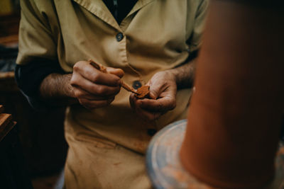 Midsection of man working at shop