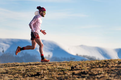 Full length of woman jumping on mountain