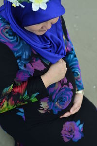 Midsection of woman standing by purple flowering plants