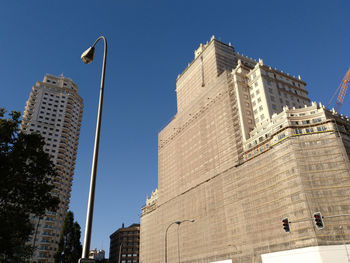 Low angle view of buildings against clear blue sky