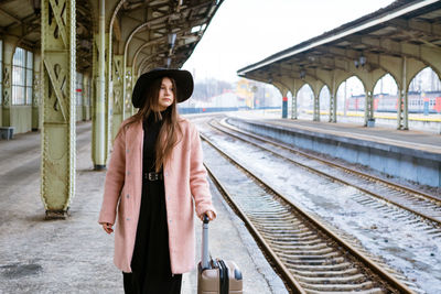 Woman traveler tourist walks with luggage at train station. active and