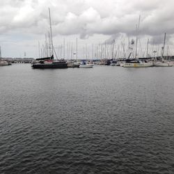 Sailboats moored on sea against sky