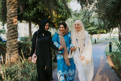 Smiling women in hijab walking in park