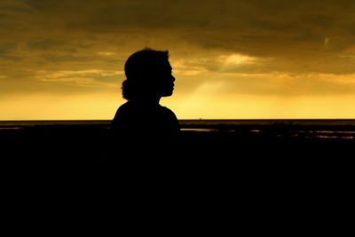 Silhouette man standing at sunset