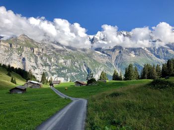 Panoramic view of road amidst field against sky