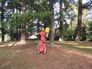 Side view of woman standing in forest