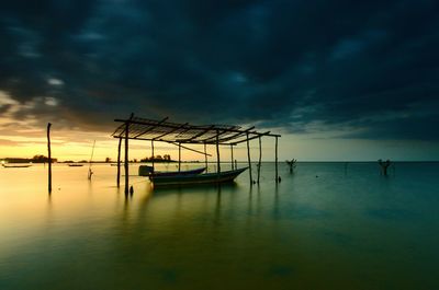 Sailboats in sea against sky during sunset