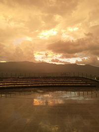 Scenic view of sea against cloudy sky at sunset