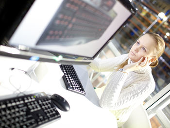 Woman using computer at desk in office