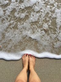 Low section of woman at sea shore