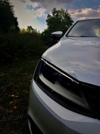 Close-up of car on field against sky