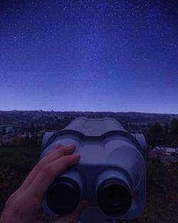 Midsection of person holding camera against clear blue sky