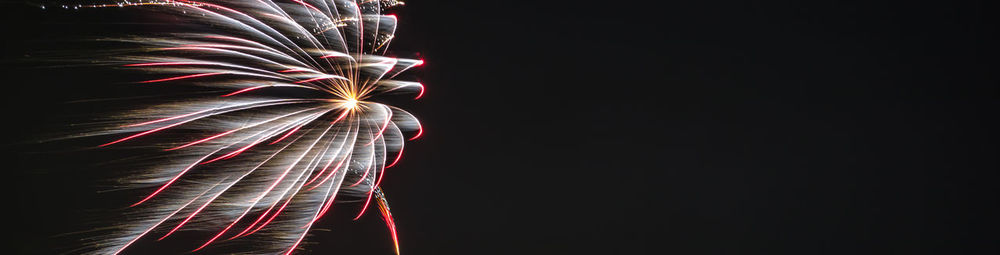 Low angle view of firework display at night