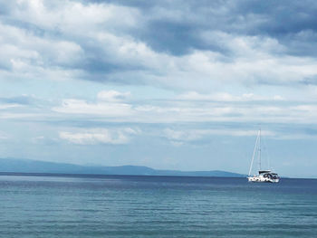 Sailboat sailing on sea against sky