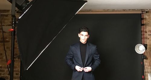 Portrait of handsome young man standing in studio