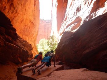 Rear view of man doing push-ups amidst rock formations