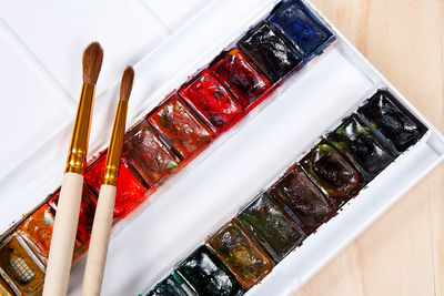 High angle view of paintbrushes on glass table