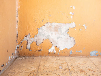 The old concrete wall with peeling paint near the corner of the old railway station.