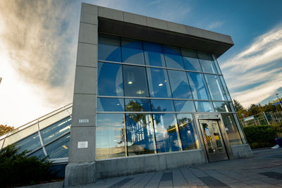 Low angle view of glass building against sky