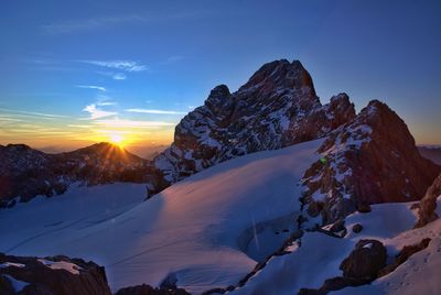 Scenic view of snowcapped mountains against sky during sunset