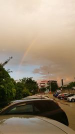 Rainbow over city street against sky