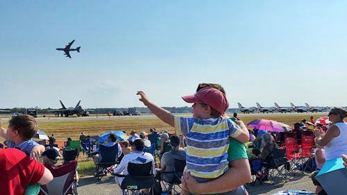 Group of people on airplane against sky