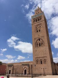 Low angle view of clock tower amidst buildings against sky