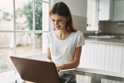 Young woman using laptop on table