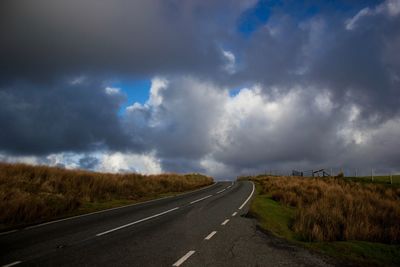 Road by landscape against sky