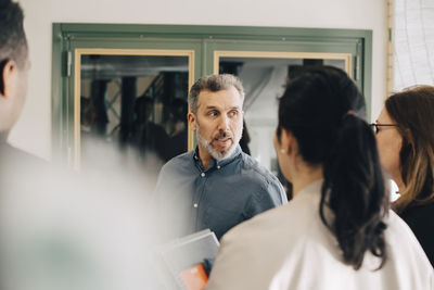 Businessman discussing with multi-ethnic entrepreneurs at conference