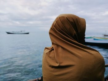 Rear view of woman looking at sea against sky