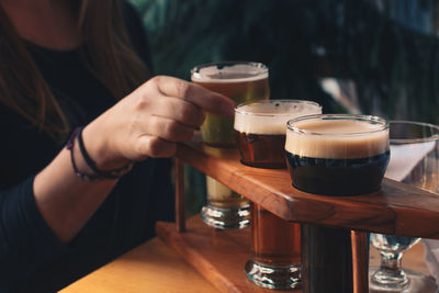 Cropped image of woman tasting craft beer at bar